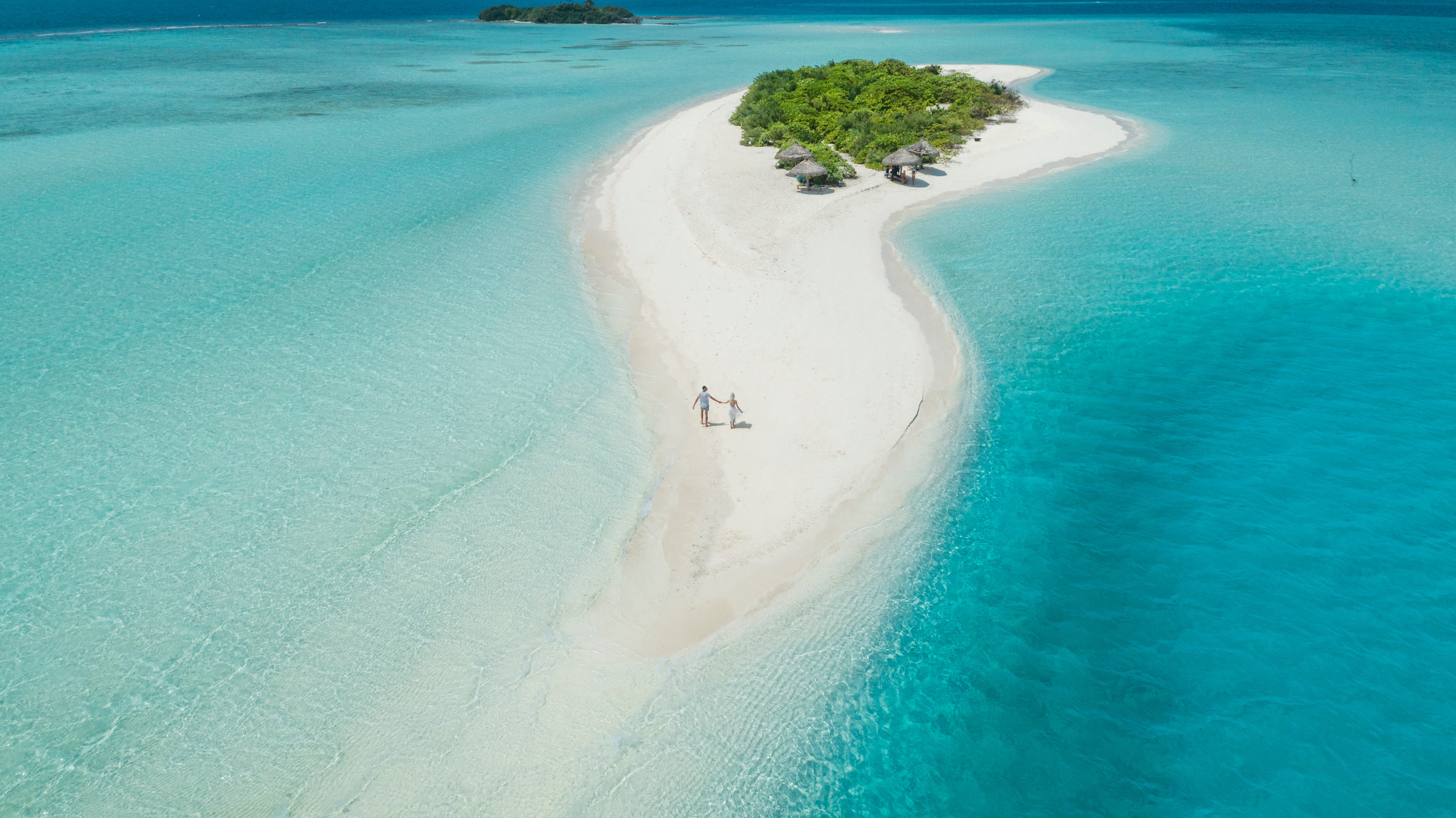 Aireal view of a couple walking on a small tropical island